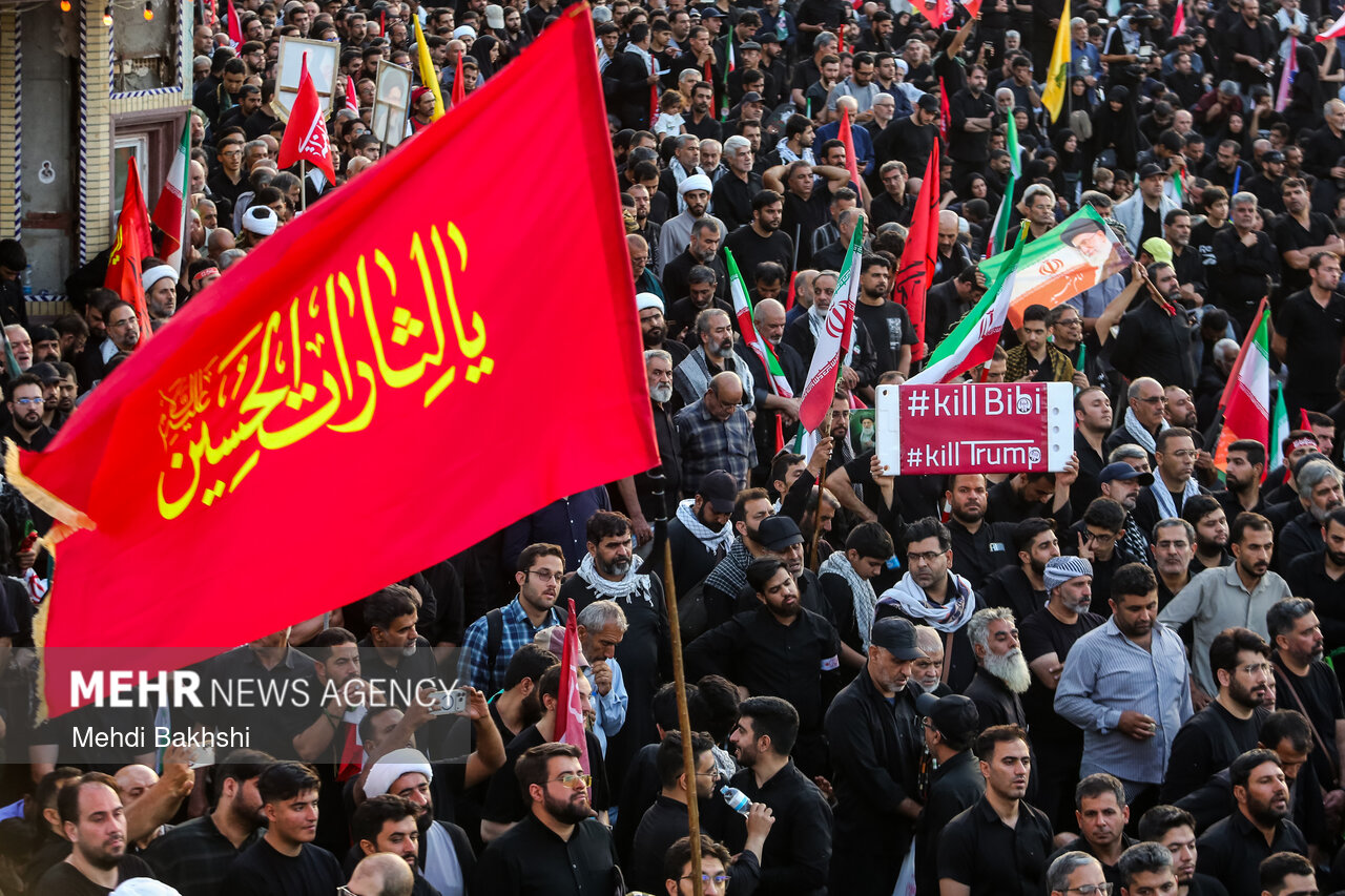 قابی از خودرو حامل پیکر امام شهدا در میان انبوه جمعیت عزادار